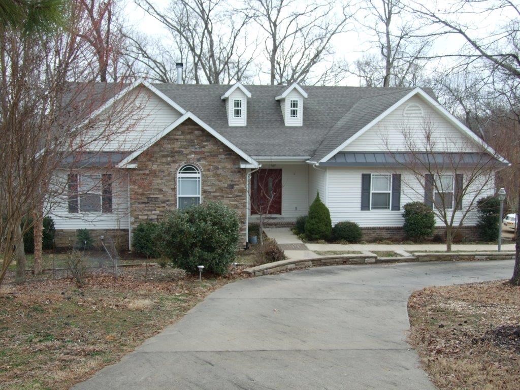 Located just east of Downtown Rogers, Lake Atlanta and the Railyard Bike Park and near to Beaver Lake and a public golf course. Two levels with open living area with three bedrooms, living room, eat-in kitchen, office, and sunroom on main level. Walkout basement with second living area, game room, exercise room, fourth bedroom, work room, shop and storage area. Enjoy wildlife and nature from the windows, deck, screened porch or patio.  Appreciate flower gardens, landscape, water fall, and mature trees.
