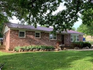 Charming all brick home in country setting on 4.82 acres, m/l. Home features a new metal roof and a new geothermal heating/cooling system. Large fenced in back yard with underground storm shelter. Yard features several large shade trees. New laminate flooring in living room and dining room. Lots of potential here in a great location!