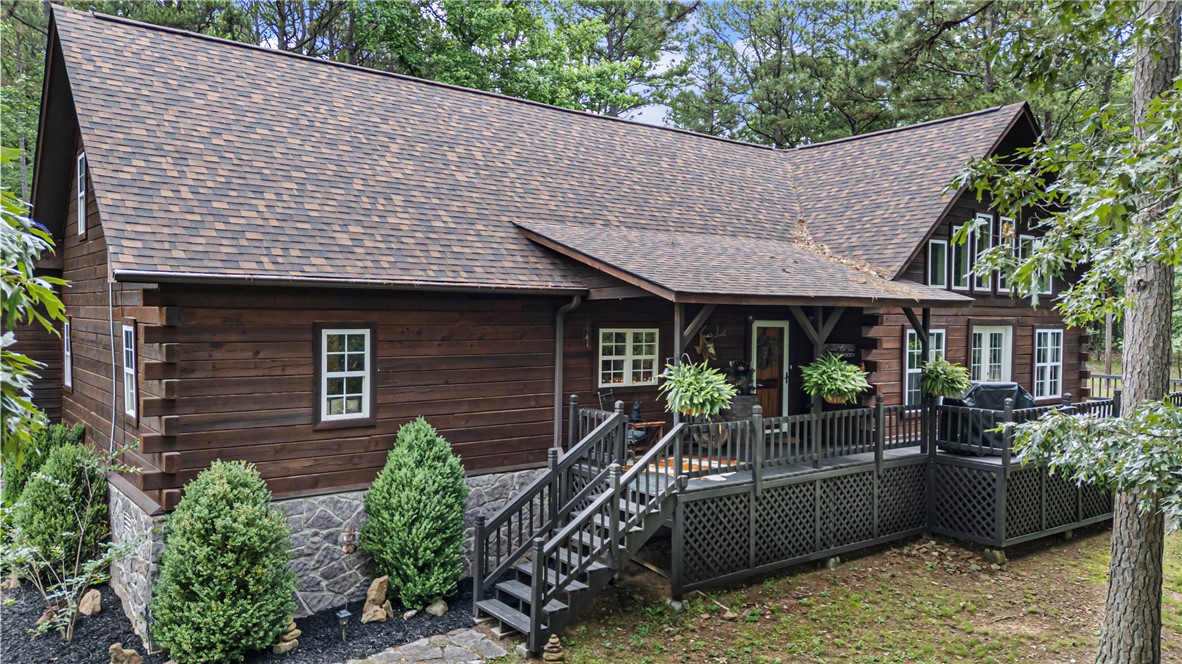 Tucked away on 2.6 wooded acres behind a private gated road, this custom built 3,334 sq ft home offers a rare blend of craftsmanship, privacy, and modern convenience. Built in 2006 using pine milled directly from the property, this 3 bedroom, 3 bath home showcases soaring 22 foot vaulted ceilings, tongue and groove finishes, and a warm lodge style atmosphere. The spacious living area features a propane fireplace, while the primary suite includes a jet tub, remodeled oversized shower, and large walk in closet with vanity. Improvements include a new roof in 2025, exterior oil sealing in 2025, new decking in 2026 and HVAC replacement in 2022. Additional features include fiber optic internet, generator wiring, easy tilt windows, a tornado shelter, owned propane tank, and propane hookup for a stove. Enjoy the gated wraparound deck, 8x16 storage building with electricity, abundant wildlife, and the peace and privacy of country living. Home cannot be seen from highway, do not enter driveway without showing approval.