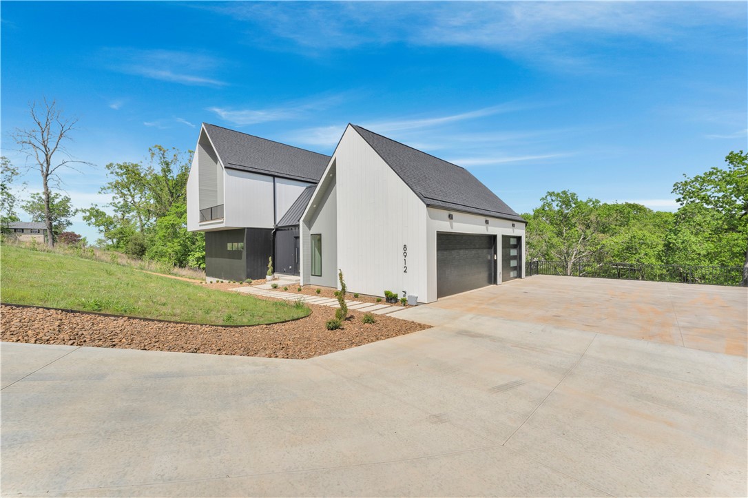 Modern architecture meets natural serenity minutes from Prairie Creek Marina on Beaver Lake and downtown Rogers. This striking three-story home impresses from the moment you enter with a dramatic floating staircase spanning all levels and serving as the architectural centerpiece. Floor-to-ceiling windows flood the home with natural light and bring the wooded surroundings in. The main level features a chef’s kitchen with large entertaining bar open to the dining and living areas. Upstairs offers a luxurious primary suite with spa-like bath and soaking tub, plus a second ensuite bedroom and flex space with balcony access. The walkout lower level includes 2 bedrooms, 2 baths, a second living area, and large storage with additional unfinished space ideal for a wine cellar, gym, or workshop. Every level opens to a private balcony with peaceful tree views and exceptional privacy. Rare modern luxury built by Key Concepts. Learn more at www.yourkeyconcepts.com