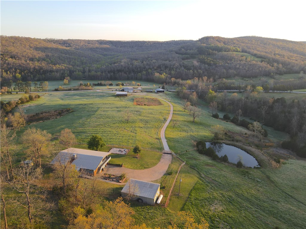 This one of a kind property has everything to offer. Upon entering through the gate, you are greeted with expansive pastures and stunning landscape. A metal shop sits at the front of the property featuring a 4 bed, 2.5 bath addition. Next to the metal building there is a fully operational cattle corral. As you pull up the driveway, you will notice the multiple out buildings and an equestrian barn equipped with stalls and tack room. The driveway continues up the gradual hillside to the main 3,789 Sq.Ft. home which has 6 beds, 4.5 baths. This home is 80% handicap accessible and has proven successful as a nightly rental. From the front porch you are able to enjoy breathtaking views of the surrounding landscape. With trails expanding to almost every corner of the property, you are able to make
your way through the forest with ease. A notable feature is a beautiful cave near the edge of one of the creeks. Following the creek up the mountain, you will come across a spring that is nothing short of impressive.