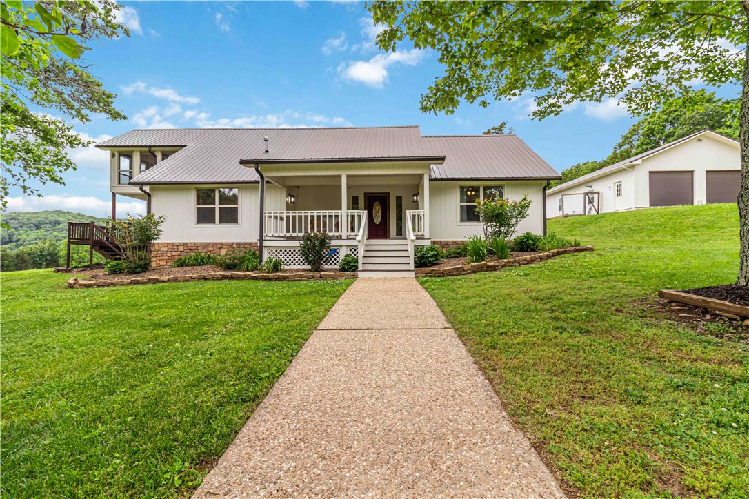 Just 20 minutes from the University of Arkansas, this stunning 87.76-acre Ozark property offers updated, move-in-ready living without sacrificing space, privacy, or scenery. The 5-bed, 3-bath main home features wood floors, a remodeled kitchen with butcher block island and stainless appliances, two living areas, and four bedrooms on the main level. Upstairs, the primary suite includes a redesigned bath, walk-in shower, and a private all-season room opening to an upper deck with sweeping mountain views. The newly replaced back deck overlooks lush pasture, five ponds, and legendary Ozark night skies. The detached 2-car garage includes a fully equipped 2-bed, 1-bath apartment (966 sq ft, not included in main home total) with covered porch, full kitchen, laundry hookup, new metal roof, and fresh paint — perfect for guests, family, or rental income. Homestead, hobby farm, or your own piece of the Natural State — this one checks every box.5k in preferred lender credits
