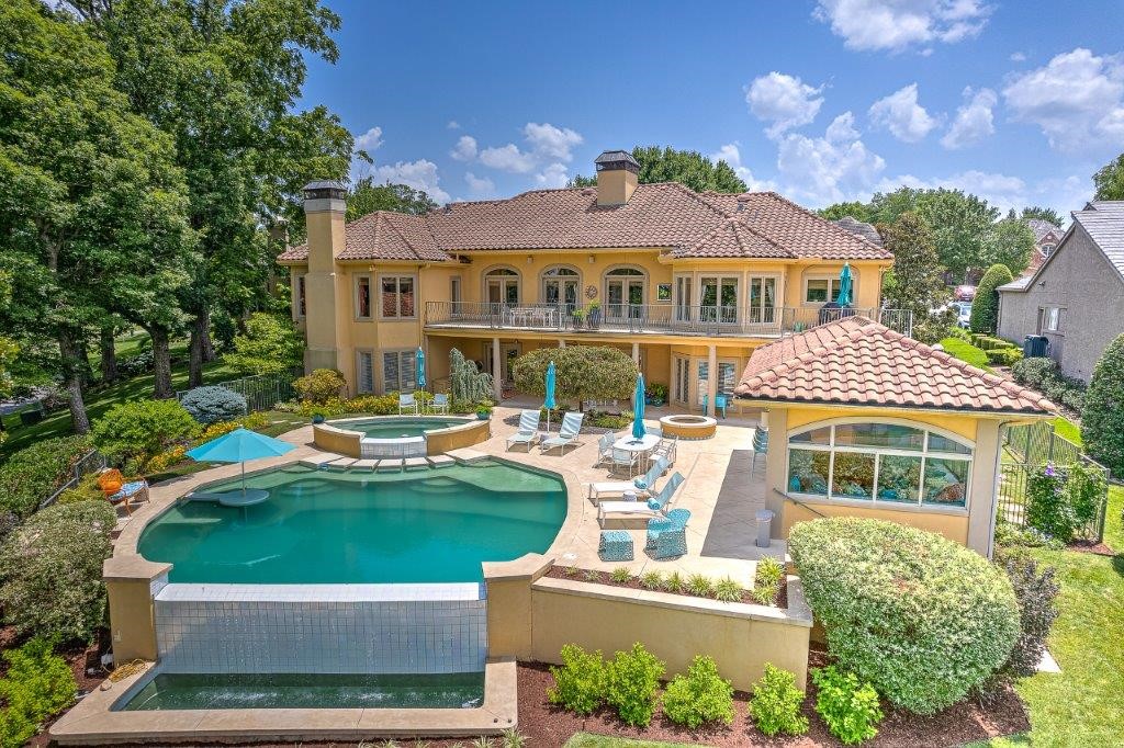 RESORT STYLE GOLF FRONT PINNACLE ESTATE OVERLOOKING THE 12TH, 14TH AND SIGNATURE 15TH ISLAND HOLES!  Custom designed and renovated to perfection, this spectacular setting boasts a backyard oasis with the private infinity pool making a seamless transition to the pond and golf course backdrop. Fully equipped poolside cabana boasts a kitchen, living, full bath and surround sound creating the ideal setting for entertaining and enjoying front row seats to the Walmart LPGA tournament!  Contemporary design elements with whimsical touches layered in fun colors and texture make the almost 6,000 sq ft interior a fun, vibrant and welcoming place to live, gather and entertain!  Main level hosts a formal living area w/ fireplace, office, formal dining, eat-in kitchen, hearth room, and a private master retreat w/ FP overlooking the golf course and featuring direct access to the main level balcony.  Full walk-out basement features living/media room w/ wet bar, bonus/living area w/ FP, 3 bedrooms, 3 baths, 2nd laundry area & more!