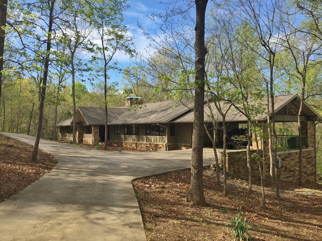 CHARMING RANCH STYLE 3 BEDROOM, 2.5 BATH HOME ON 5 ACRES WITH COMPLETE RENOVATION IN 2014!  Just 3 blocks from the University of Arkansas Razorback Stadium, this beautifully remodeled home offers tree house living with large decks that extend the length of the home.  Sleek and modern kitchen with quartz countertops, island, stainless appliances w/ gas range and double ovens!  Cozy master suite with fireplace, hardwood floors throughout, open living area with fireplace!  A truly unique property in the middle of town!