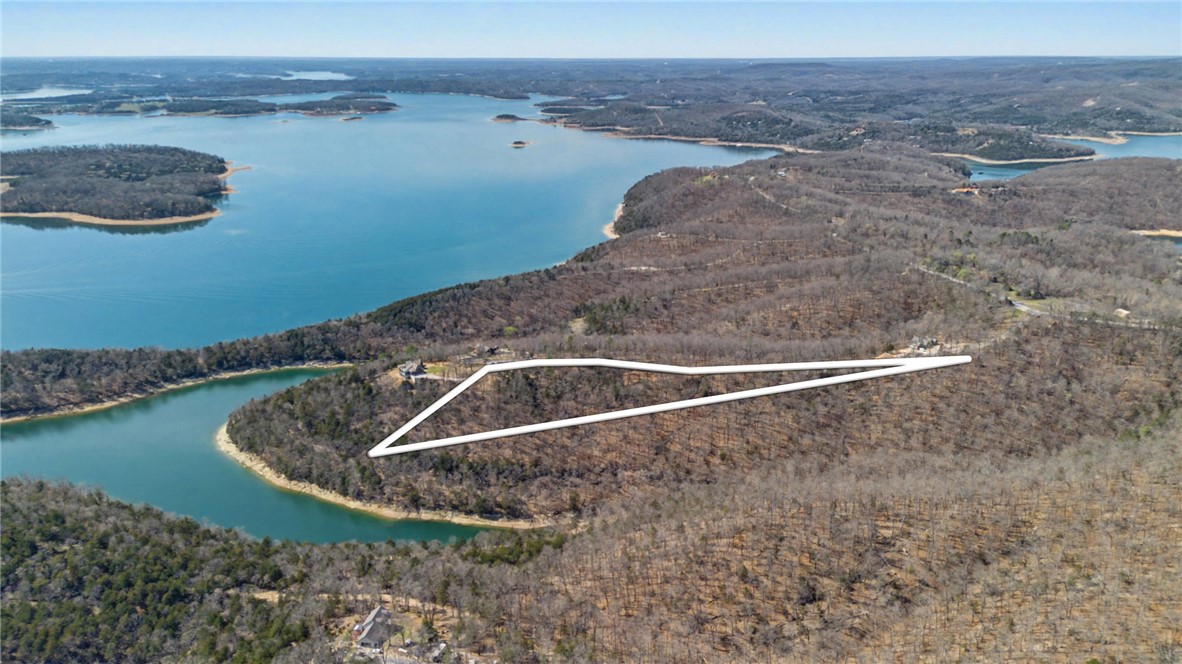 Ready to build your dream home or lake getaway? This lot is a rare gem in a small, curated neighborhood of nine total lots with two existing homes and two under construction. A lighted, landscaped cul-de-sac at the interior of this secluded community and a gated entryway provide an elevated experience as well as privacy and security. Large, wooded lots allow owners to situate their future home perfectly to capture views and preserve natural views on the largest lot in the subdivision. Just across the road and down the hill (4WD needed), access the community dock and swim platform near your included 12/30 boat slip with locker. You’ll be on the water in some of the most idyllic parts of Beaver Lake just minutes after walking out your front door. This lot already boasts a well, saving you money and getting you closer to building your dream home.