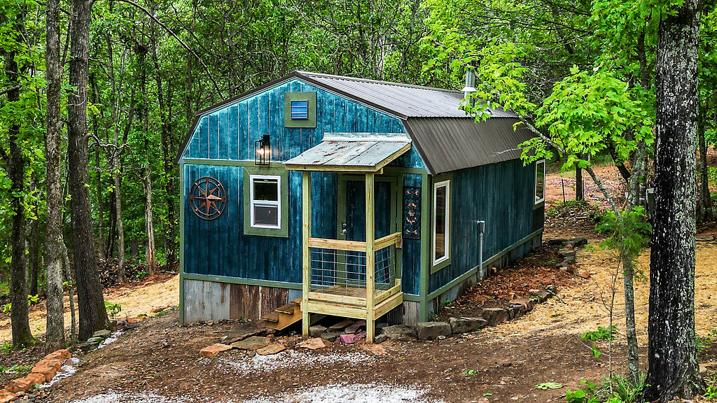 Charming tiny home retreat nestled in the scenic beauty of Winslow, Arkansas! Surrounded by huge trees and abundant natural light, this peaceful property offers postcard-worthy view and a serene setting perfect for relaxing or entertaining. Inside, you'll find high-end fixtures and a stunning oversized soaking tub with a view. The beautifully designed landscaping and custom stonework by a master stoneworker create exceptional curb appeal and outdoor charm. Additional features include two extra building sites- ideal for a shop or garage. Conveniently located near fuel, shopping, dining and approximately 23 minutes from the University of Arkansas. A rare opportunity to enjoy Ozark living in an idyllic setting!