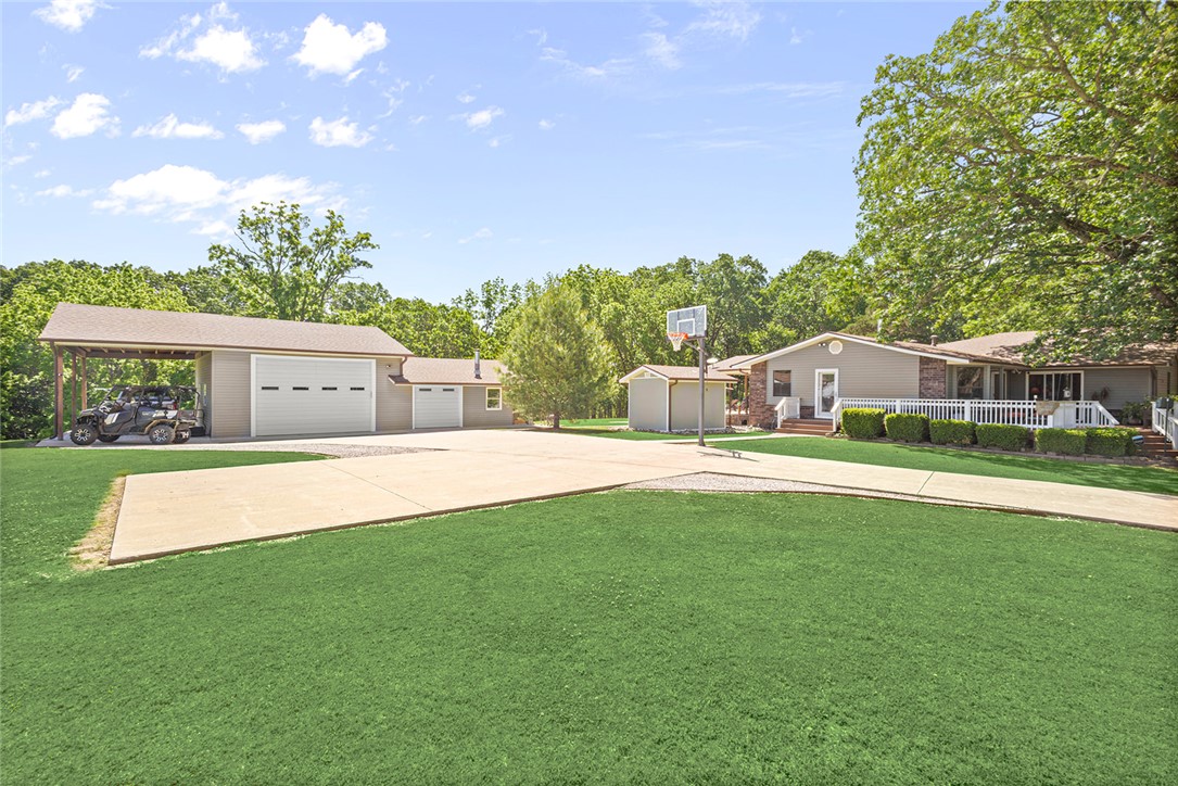 This ranch style home on four acres offers seclusion and convenience! The land is saturated with large beautiful oak trees overlooking expansive rolling hills. But, conveniently located just 5 miles to I49 and 7 miles to Downtown Bentonville!  Property features primary ranch style home, a secondary potential dwelling unit, a workshop with 10' garage bays, an RV car port AND a large vintage red pole barn. This property is the gift that keeps on giving! Quaint farmhouse kitchen open to dining space and large living area. Primary bedroom offers ensuite full bath opening to large laundry room. Most of the large back deck is covered offering the perfect place for entertaining or just relaxing and taking in the views. New roof, HVAC and water heater.  This property is the perfect blend of what Northwest Arkansas has to offer!