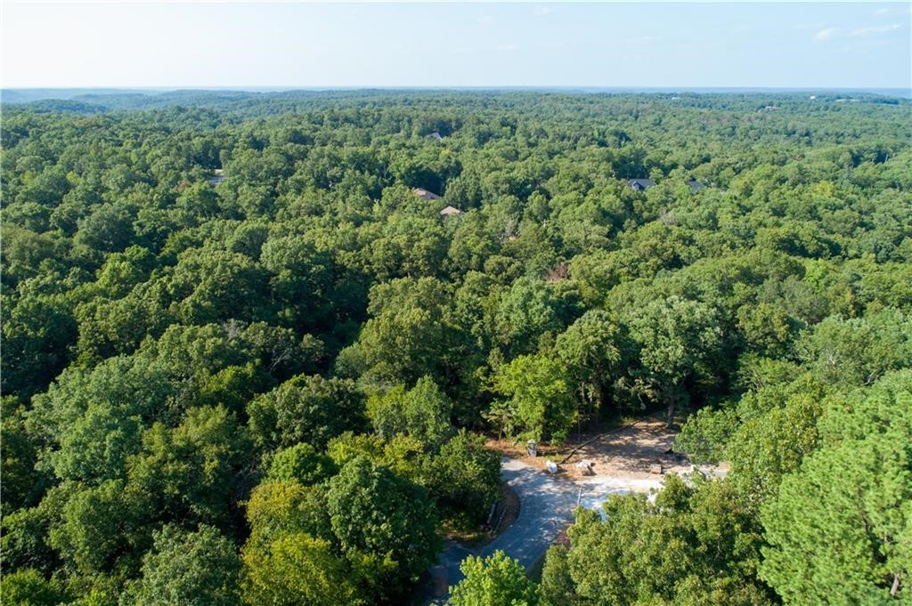 Explore a 0.39-acre wooded retreat, offering tranquility in abundance. Situated on a quiet street, you can fully embrace a life of peace and privacy. Picture yourself in this haven, surrounded by nature's beauty.This lot holds the promise of endless possibilities. Adding to its allure, this lot enjoys a prime location just a short drive away from both downtown Bentonville and Rogers. The prestigious Highlands golf course is a mere six minutes away. For mountain biking enthusiasts, the world's top trails beckon, waiting to be explored nearby. But that's not all—with just a brief five-minute drive, you'll find yourself at the Branchwood Recreation Center. This facility offers tennis and basketball courts, an indoor swimming pool, a well-equipped gym, a nature trail, and even a frisbee golf course. Don't let this chance slip away – reach out today and secure your own slice of serenity.