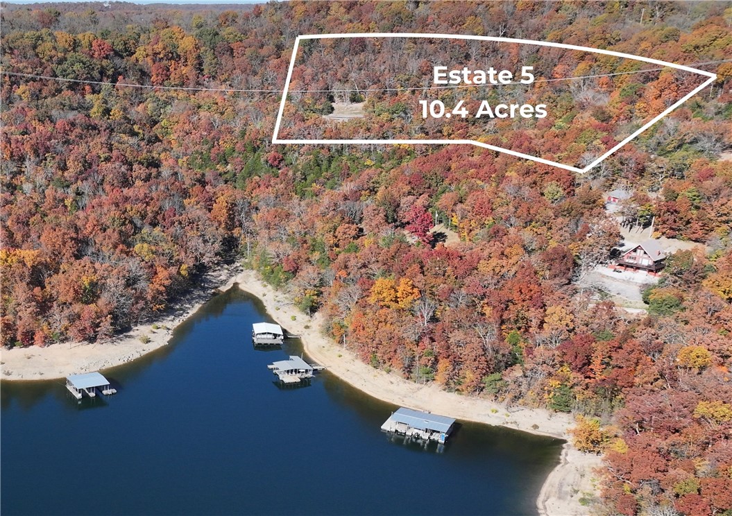 Set high above Beaver Lake on a dramatic limestone bluff, Estate Site 5 captures a 270-degree sweep of water and rolling Ozark hills that few properties in the region can match. This 10.4-acre homesite inside The Reserves at Arrowhead Cove offers a rare blend of elevation, privacy, and natural beauty, where every angle feels like a living postcard. The flat-topped bluff creates an exceptional setting for a custom residence designed to embrace the horizon, with sunrise light from the east and sunsets casting golden reflections across the lake. Mature hardwoods and natural rock formations add character throughout the landscape, while the gated entrance offers peaceful seclusion. Despite its tucked-away feel, the public boat ramp is just minutes away. Envision a modern lake house, timeless estate, or luxury retreat tailored to your lifestyle. Paved roads, underground utilities, and community water are already in place, making it easy to partner with custom home builder-Beaver Lake Homes -and bring your vision to life.