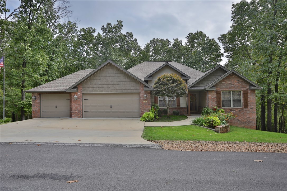 Beautiful inviting home nestled in picturesque setting surrounded by landscaping and hardwoods.  This 4 bedroom 3 bath is perfect for you and your family!  2 bedrooms on main level, hardwood floors, granite throughout with screened porch.  Walkout basement featuring 2 bedrooms and second living area.  Large partial covered deck allows for entertaining.  Enjoy this home inside and out.  3 car garage, on Bella Vista sewer. New HVAC & Heat Pump January 2016.  Must see!! Adjacent lot also available.