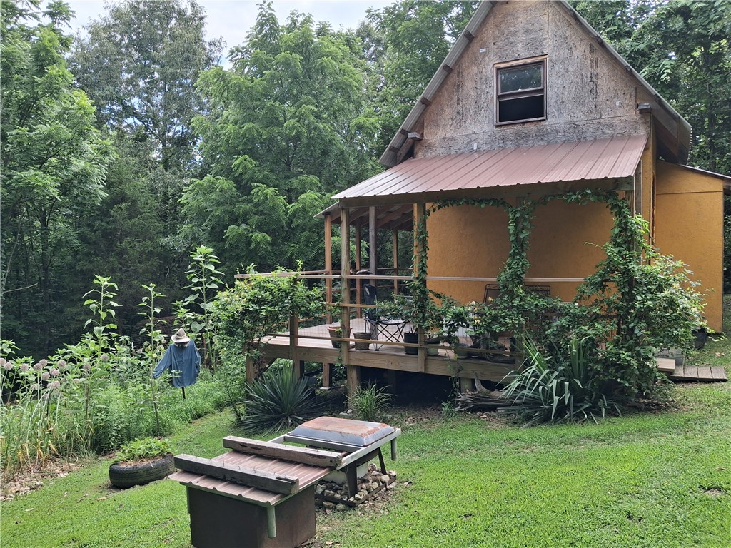 Escape to a simpler way of life with this charming primitive cabin tucked away on 5 beautiful acres of unrestricted land. Surrounded by nature and offering complete privacy, this off-grid retreat is perfect for homesteaders, outdoor enthusiasts, or anyone seeking peace and self-sufficiency. The cabin was designed for sustainable living, featuring an informal rainwater collection system, efficient wood heat, and an unsophisticated composting outhouse. The property boasts a huge established garden area with plenty of room to expand, making it ideal for growing your own food and embracing a self-reliant lifestyle. Meandering along the cleared trails throughout the acreage, providing opportunities to explore, watch wildlife, and connect with the natural surroundings right outside your door. Counting stars has never been so inviting. NO WELL, NO SEPTIC ***PLEASE DO NOT DISTURB OCCUPANTS