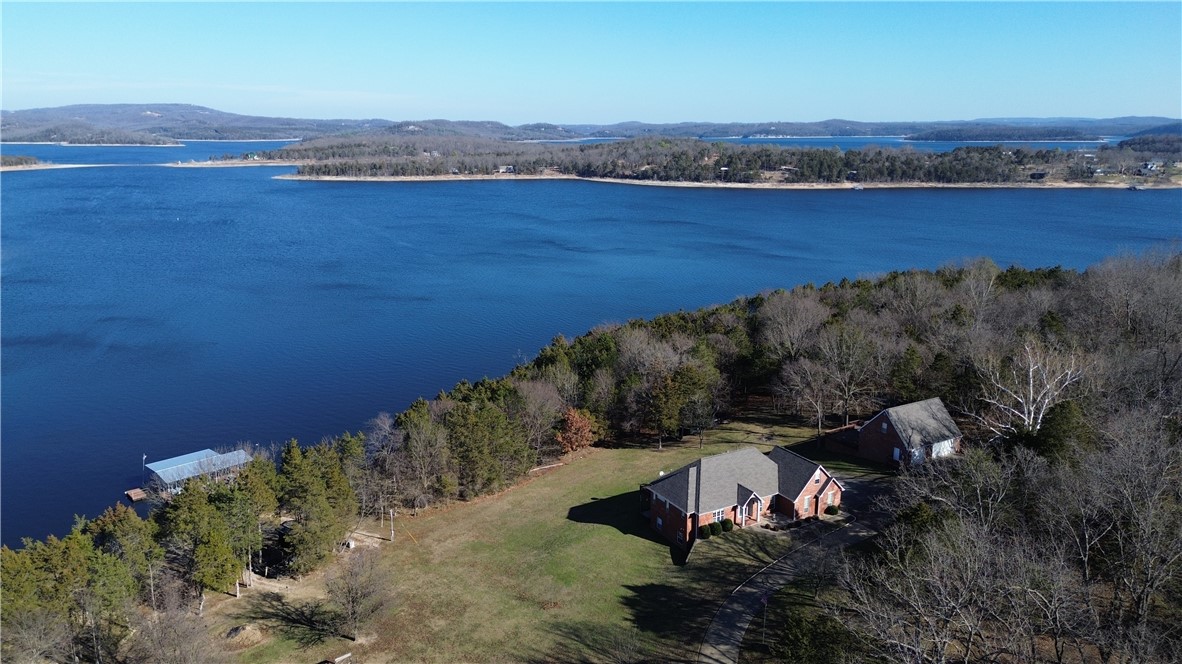 A rare opportunity on Beaver Lake in coveted Ventris Point, this custom-crafted home blends timeless design with thoughtful engineering. Set on over 3 acres in one of the lake’s most protected deep-water coves, the property offers privacy, durability, and exceptional lake access. Vaulted ceilings, granite counters, energy-efficient features, abundant storage create a home designed for comfort and function. Private dock features oversized 30x32 slips with lifts, two swim platforms, sea anchored—ideal for year-round enjoyment. Multiple garages (attached and detached) provide five total bays plus bonus rooms, perfect for hobbies, guests, or future expansion, also treehouse and another storage building by water. Recent improvements include new roofs, gutters, HVAC, generator, dock upgrades, and extensive system updates. Landscaped, wooded, and gated, with paved access and private utilities, this is a true legacy lake home—engineered to last, designed to live in, and positioned for unforgettable Beaver Lake living!
