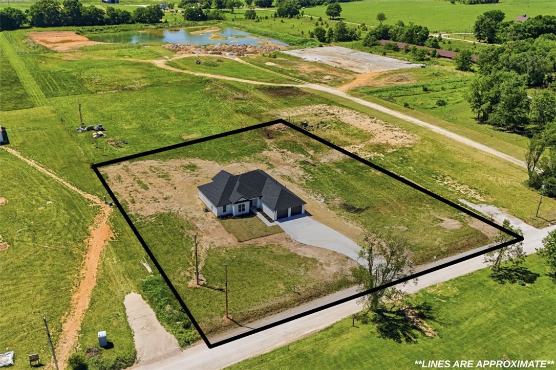 Gorgeous new construction home on 1.5 acres, offering 2,500 sq ft of style & functionality! This 4-bedroom, 3 full bathroom home is conveniently located south of Tontitown in West Fayetteville & designed for modern living, featuring an open floor plan ideal for entertaining & everyday comfort, along with beautiful finishes & vaulted ceilings throughout for added warmth & character. Primary suite is a true retreat, featuring a massive walk-in closet with extensive built-ins, including two full dresser systems, while the en-suite bath offers a dual vanity, walk-in shower & relaxing soaking tub. Front bedroom includes a built-in desk with overhead storage, perfect for a home office, study space, or creative area. Step outside to the covered patio with vaulted wood plank ceilings & an oversized fan, creating a great space to relax or entertain year-round. Enjoy the privacy of 1.5 acres while still being minutes from town—style, space & location come together in one exceptional opportunity you do not want to miss.