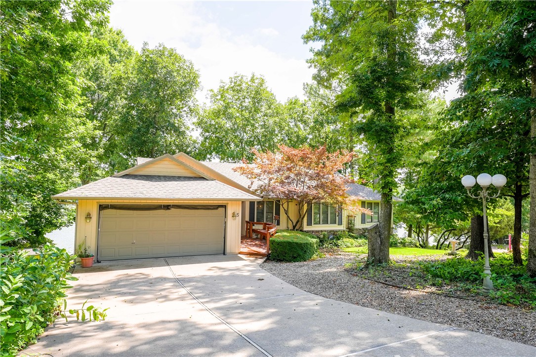 Welcome to your dream home on Loch Lomond!This extraordinary property offers over 300 feet of pristine lakefront, providing some of the most spectacular and panoramic views available.Gently sloping from the home to the water’s edge, the setting is as inviting as it is scenic.Enjoy not 1, but 2 covered boat docks.The home has been thoughtfully remodeled, freshly painted, and updated throughout—including a fantastic new 4th bedroom on the lower level, featuring double doors that open to the outdoors.The cathedral-ceiling living room is anchored by a striking stone fireplace, while the sunroom offers breathtaking views of the lake—perfect for morning coffee or evening relaxation.With a newer HVAC system and a roof replaced in 2019, the essentials are already taken care of. In addition to the attached two-car garage, you’ll find an extra garage for all your storage needs.Nestled on one of Bella Vista’s most prestigious cul-de-sacs, this home truly has it all. Come home to Loch Lomond, your lakefront lifestyle awaits!