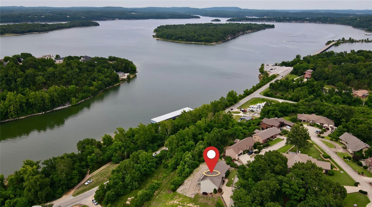 Wake up to beautiful scenic views of Beaver Lake! This home has been meticulously maintained, provides a functional and inviting layout that offers great entertaining space both indoors and out. The main level features a well appointed kitchen with amazing views, a large living room overlooking the lake, separate dining room, oversized utility room, half bath, and primary bedroom/bathroom. The finished basement offers 2 additional bedrooms, full bathroom, a game room/2nd living room with kitchenette, plus a space perfect for home office or exercise room. Walk-out access to the 2 story deck from either level. 36" doors throughout. Surrounded by the natural beauty of Northwest Arkansas, this property offers a peaceful setting just minutes from Downtown Rogers.