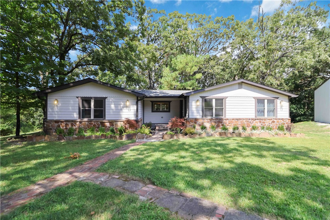 A private West Fayetteville retreat beside Centennial Park, minutes from I-49 and the University of Arkansas. Updated in 2021, this 3-bed, 2-bath home sits on 1.49 acres with mature trees, sunset views, 2 patios, 2 living areas, and a 30 x 50 shop. Ideal as a full-time residence, game weekend getaway, U of A home base, or private retreat in the middle of Fayetteville city living.