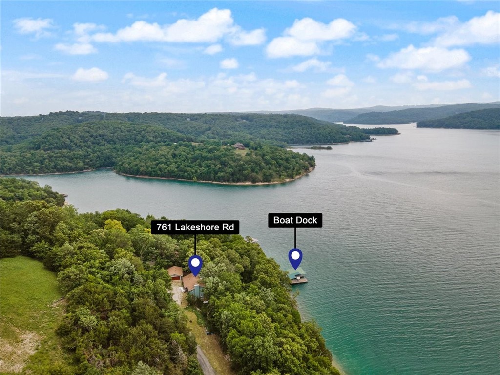 Private w 2 slip boat dock with a lift and swim platform.  Year round lake views.  New Roof!  New Heat and Air system!  Covered back patio and cover front porch.  2 car detached garage.  Home has lots of extra builtins with specialty woods like Tiger Maple kitchen cabinets w granite countertops. Wood floors are custom made Spaulted Maple and lower level builtins are all Cherry wood. Bedroom and bath on each level. Walkin closet in each bedroom.  Seller is recently disabled and moving to be near family. Wired for sound but no speakers. Owner has recently connected to Starlink internet. Additional storage in garage and lower ground level metal carport is for covered storage for lake toys and yard equipment. Seller has handicap permit with atv trail to dock (marked w pink Ribbons.) Lots of paved road frontage for gardening. Home has the potential to be fabulous. Originally 4 bedroom home, family room now, minus 2 Bdrm Family Room can become additional bedroom areas if needed. Builtin desk/work area in lower level.