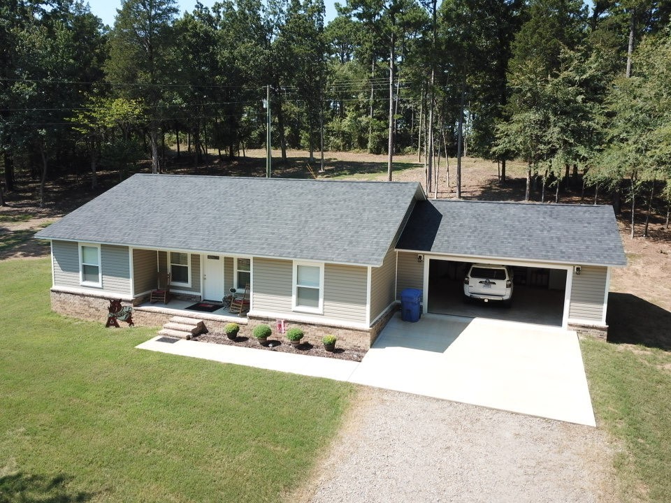 This impressive 1,500 sq ft residence features a two-car garage and is topped with a new architectural shingle roof. The interior boasts luxurious tile flooring throughout, set on a solid concrete slab. The home includes three bedrooms and two bathrooms, each adorned with thick granite countertops in the kitchen and bathroom vanities, as well as in the master walk-in shower, which showcases exquisite tile and granite work. Quality fixtures and faucets enhance the overall aesthetic while custom wood cabinets are featured in the kitchen, bathroom vanities, and laundry area. 
Situated on a 3-acre lot, the property is surrounded by a newly sodded grass yard that compliments both the home and shop. The new 30'x30' shop includes an insulated 12' garage door and 12' sidewalls allowing for easy future expansion. It features two windows and is equipped with a new AC and heating window unit. The property has a large gravel circular driveway, accented with brick columns and a new privacy fence. This is a must-see property!
