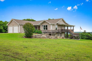 PANORAMIC WATERFRONT LAKE VIEW is what you see with level 5 acre yard and 30x40 shop building.You know this place is special! If privacy is desired,  you have it here, surrounded  three sides by Corp property.  Home is solid, custom built with open-concept design and hardwood floors. Kitchen features solid wood custom cabinets with tilt out drawer under sink,  pull out drawers for pots& pans, & dividers for  cookie sheets. The sink view is looking out over the lake!!!   The full semi-finished basement has another living room, bath and storage galore for all the guests that will want to come visit.  It has walk-out doors on huge deck and with patio overlooking Bull Shoals Lake. Yard is flat, so play all day!! Then, it is only 1/2 mile to boat ramp,  so be sure to bring the boat!