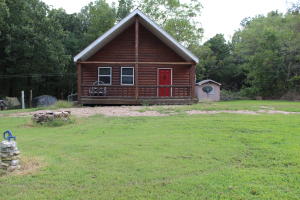 Log home in the Ozarks! This 2 bed 1 bath home has covered front porch to sit and enjoy the wild life or sit on the back deck in the hot tub and enjoy the privacy of the woods. Home features city water, metal roof, storage shed, wood floors, vaulted ceiling in living room with second bedroom in loft. Only minutes to the Crooked Creek or Buffalo National River.