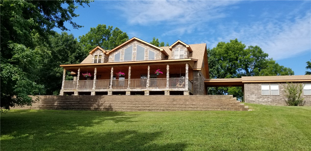Beautiful, Beaver Lake, custom rock, brick and cedar 2-story home located in quiet, peaceful neighborhood at Beaver Lk. This 3-BR, 2.5-BA with loft, lake home sits in the middle of three large lots with beautiful mature trees and a seasonal lake view in winter and spring. Home has detached 2-car garage with covered breezeway. 2 minutes away is a boat slip with lift and private parking area on Kelly Creek/Friendship Cove. Boat dock conveys. Interior has raised, paneled, knotty alder cabinets and pine/cedar throughout. Large covered front porch for sunrises, covered back porch for sunsets and breezeway to enjoy either!