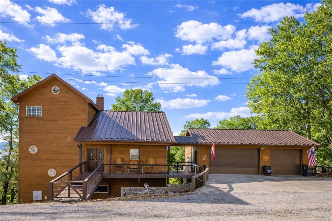 Incredible opportunity to own this gorgeous, custom built three-level cedar home on 3 lots overlooking Beaver Lake! Enjoy stunning lake views from the home and three decks, just minutes from Rogers and Eureka Springs. This home features 3 bedrooms, 3.5 baths, an open kitchen/living/dining layout, granite counters, walk-in closets, and tons of storage. Chef’s kitchen with induction stove. The lower level offers a second large living area with a full wet bar, perfect for entertaining. An additional 918 SF heated and cooled man cave/storage is not included in total SF. Three-car attached garage, two-car detached garage, plus parking pad. Community amenities include a nearby Recreation center with fitness facilities, pool, and courts. All furniture and appliances convey! Ideal as a primary residence or vacation home! Boat conveys with full price offer. It is docked at Rocky Branch Marina. Slip is leased and Buyers have first option to continue.