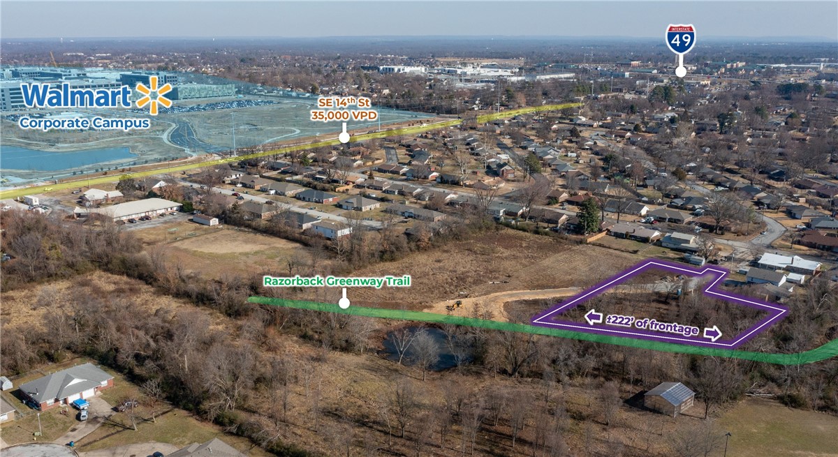 This premier property offers exceptional visibility and long-term value with approximately 222 linear feet of frontage along the newly constructed Razorback Greenway Trail. Ideally positioned next to Bentonville High School—known for strong academic performance, above-average test scores, and a high graduation rate—the site is fully equipped with all utilities and ready for development in one of the area’s most sought-after locations. The property sits just 0.3 miles from the Walmart corporate campus, 0.9 miles from the Sam’s Club corporate office, 0.3 miles from SE 14th Street with 35,000 vehicles per day, and only 1 mile from I-49, which sees 95,000 vehicles per day, offering unmatched connectivity and exposure.
