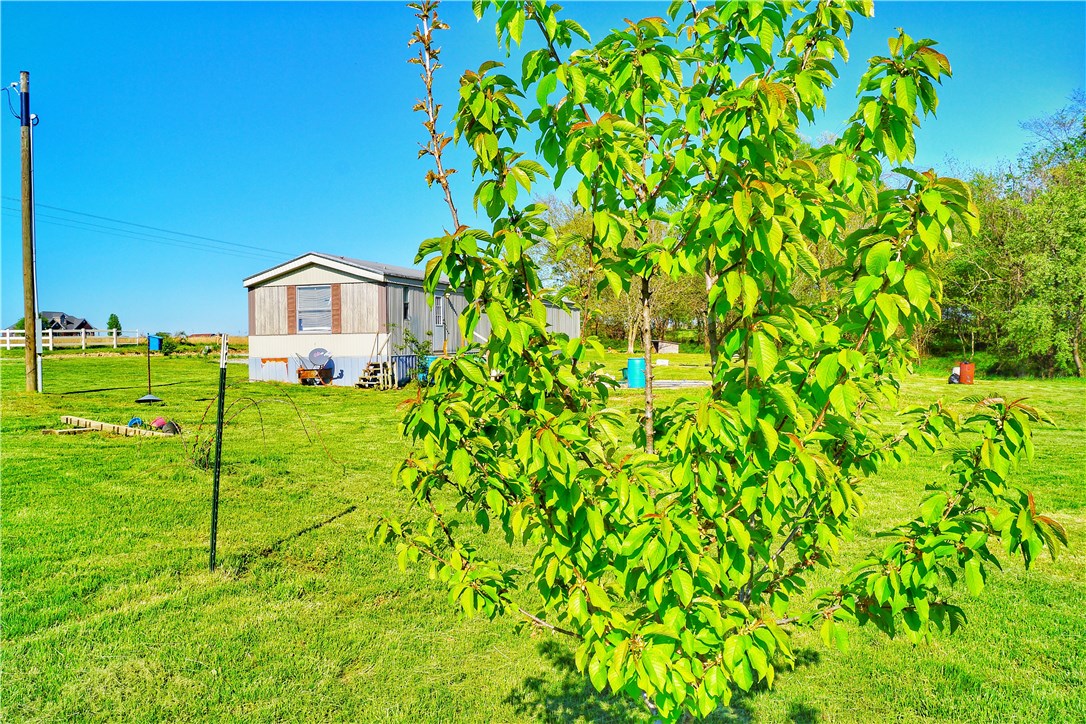 Beautiful 2.5 acres with scenic views, yet close to Siloam Springs & Gentry!  This could be an amazing building site!  2 acres is cleared with beautiful trees and shrubs.  Many fruit trees, berry bushes, shrubs, flowers, etc.   Affordable 3 Bedrooms, 2 baths with wood-like laminate flooring, Master bath with Garden tub w/separate shower, Master Walk-in Closet, & Refrigerator included.  Large front deck/porch and so much potential! Newer Water Heater & Furnace.   City Water!