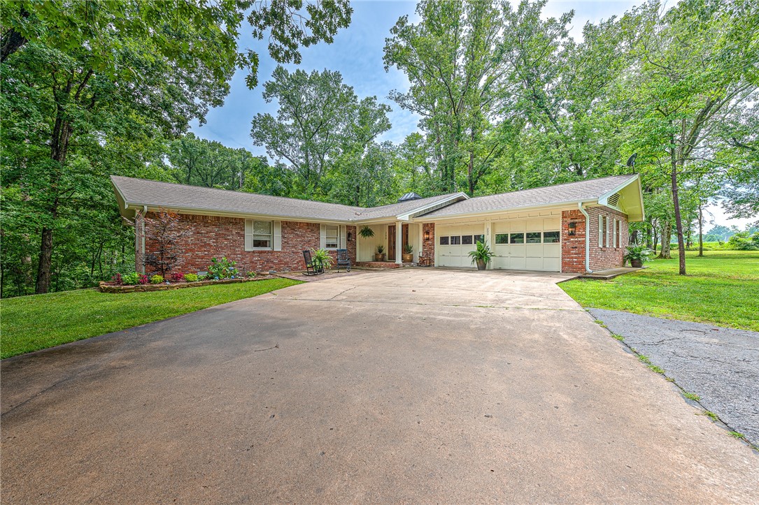 WOW! Your dream property awaits! Nestled on 4 private acres, this hidden gem showcases a fully renovated 3,546 sq ft showstopper, brimming with custom features and gorgeous details! A detached 1,500 sq ft shop offers endless possibilities! The interior offers a clean, sleek, and farmhouse flair featuring new luxury LVP flooring, designer lighting & custom millwork throughout—including rustic wood beams. The stunning chef’s kitchen boasts a 12’ island, quartzite countertops, gas cooktop and walk-in pantry. Charming living room w/ cozy wood burning fireplace and a spacious & bright dining space that walks out to the fabulous new cedar deck enjoying private wooded views! Luxurious primary and guest suites on the main level, each with stylish, high-end bathrooms! Full walkout basement w/ bonus/second living, bedroom & full bath with an additional newly added updated bedroom! Peaceful country living just 15 minutes or less from Beaver Lake/Prairie Creek Marina, the new Walmart campus, I-49, Sam’s Club and more!