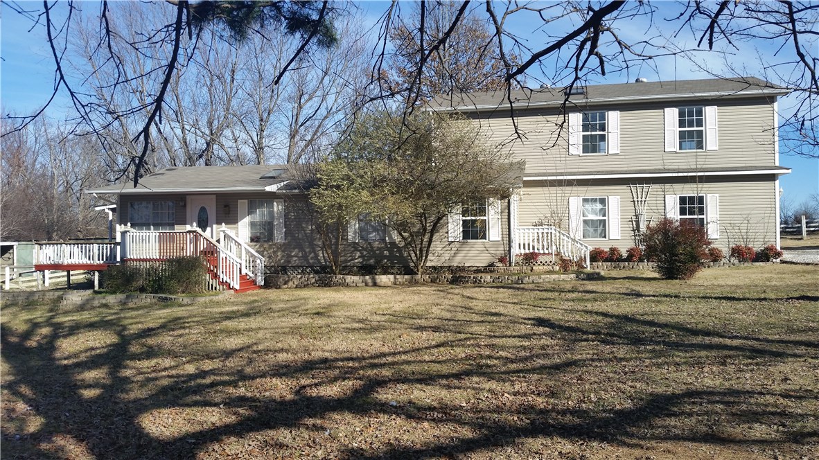 Wonderful home just a short distance to I-49 & Fayetteville, yet with a feel of country. Amenities include 3 bedroom, 2 baths, 2 living areas, a huge deck over looking 4.28 acres of beautiful grounds that feature a huge pond. Other features include an oversized garage, outbuildings and a large utility room.
