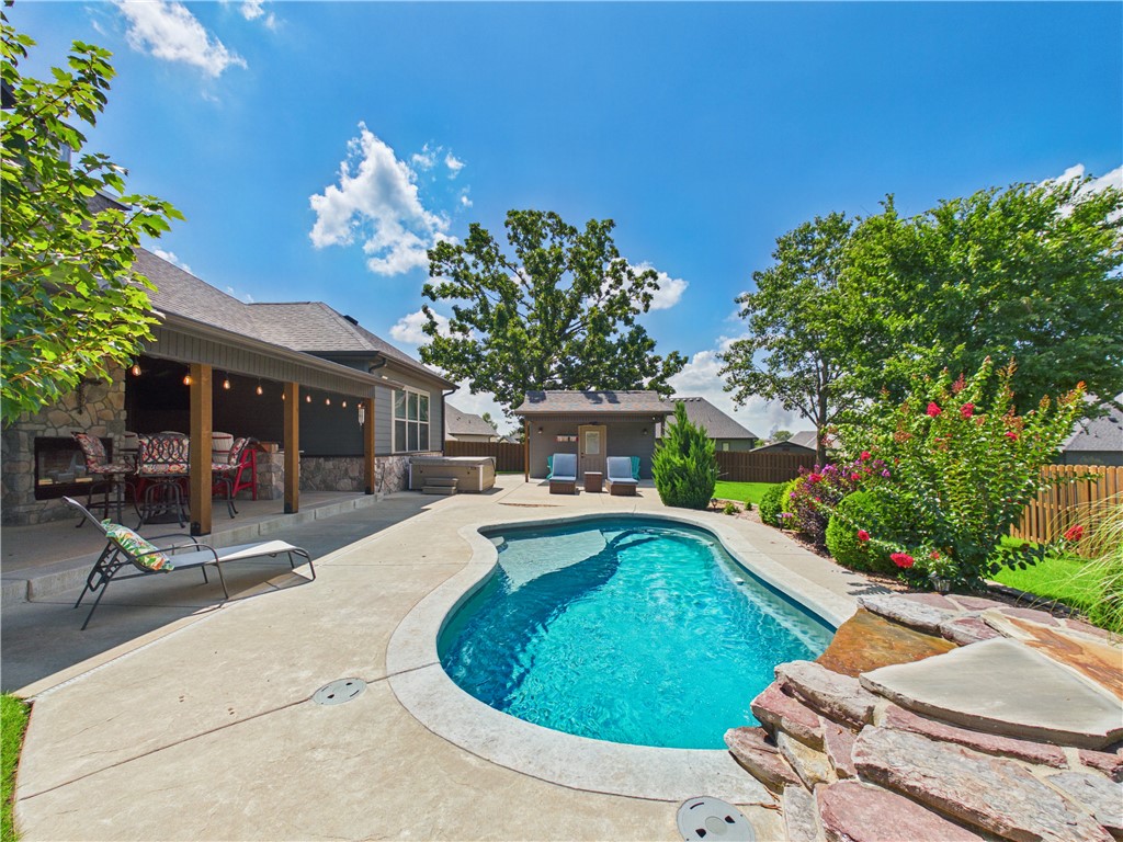This stunning custom-built, one-level home is the complete package with .43 level acres on a cul de sac. The living room sets the tone with cathedral ceilings, wood beams, stone fireplace & transom windows flooding the space with natural light. The kitchen is a chef's dream — gas cooktop with pot filler, huge granite island with farmhouse sink, under-cabinet lighting & a walk-in pantry that doubles as a safe room. The primary suite features bay windows, a tray ceiling with wood accents, walk-through tiled shower with rain head, soaking tub, double vanities, & a closet with built-in dresser & seating. The mud room off the garage offers a custom drop zone & sink. Outside, a fiberglass pool with waterfall, 5-person hot tub, outdoor kitchen, double-sided fireplace, covered patio & detached workshop create a true backyard retreat. Three-car oversized garage (3rd bay heated & cooled), tankless water heater, central vacuum, full irrigation & professional landscaping complete this exceptional home. Ask for Feature Sheet!