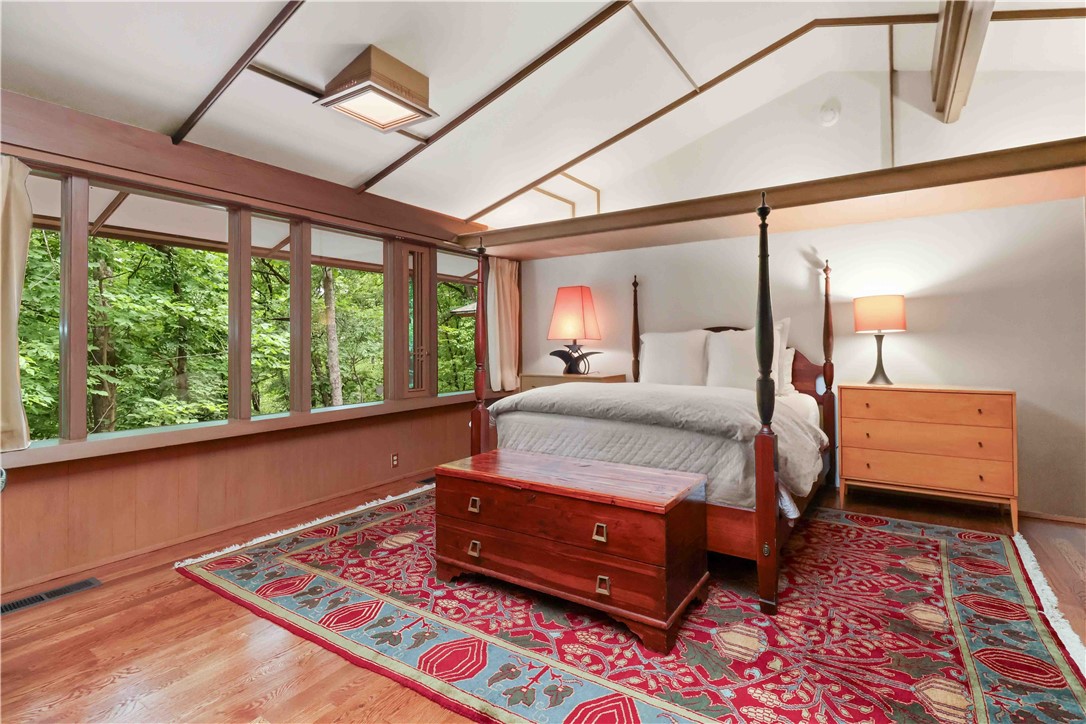 This architecturally significant residence is more than a home—it is a piece of Arkansas design history and a rare opportunity to own a true masterpiece of a renowned architect tucked into the wooded hillside of historic Mount Sequoyah. Originally designed in 1963 this home features, native stone, soaring cathedral ceilings, dramatic geometric detailing, expansive walls of glass, and rich wood elements create a timeless architectural experience filled with natural light and treed views from nearly every room. Situated on approximately .74 acres, this 3-bedroom, 3.5-bath residence offers 2780 square feet of thoughtfully designed living space with multiple living areas, striking fireplaces, built-ins, skylights, and exceptional craftsmanship throughout. The gardens enhance the home’s peaceful, secluded setting while remaining minutes from downtown Fayetteville, the University of Arkansas, parks, schools, shopping, and medical facilities. Even better: 797 s.f. garage with half bath and industrial sized doors!