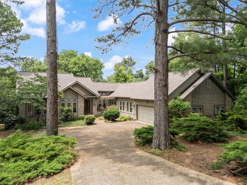 WOW! This beautiful 3-bedroom, 2.5 bath home offers outstanding curb appeal and sits on an incredible flat double lot (.71 acres) surrounded by mature trees. Recent updates include new LG stainless steel appliances featuring a dishwasher, microwave, and electric range, along with new carpeting in all three bedrooms. The hardwood flooring in the living and dining areas has been professionally refinished, and new luxury vinyl plank flooring has been installed in the den/family room. Abundant windows throughout the home fill the living spaces with natural light and provide beautiful views of the outdoors. The oversized 2-car garage offers plenty of room for vehicles and storage, plus a separate workshop located at the back of the garage - perfect for hobbies, projects, or additional workspace.