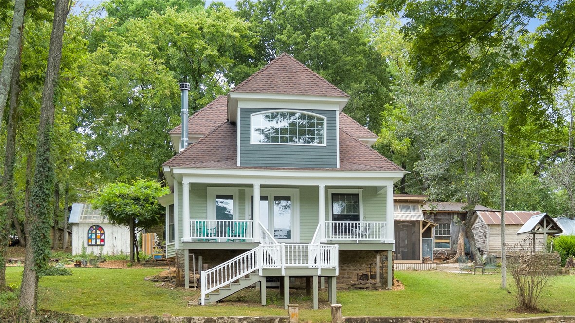 Tucked away on 4.32 private acres just outside Fayetteville, this one-of-a-kind property offers the perfect blend of charm, comfort, and outdoor living. The 2,305 sq. ft. home is rich with character, featuring pine tongue-and-groove flooring, restored wavy-glass windows, and inviting spaces throughout. Gather around the living room fireplace or enjoy the screened-in patio complete with its own fireplace and peaceful nature views. Radiant heated kitchen floors bring added comfort, while a queen Murphy bed creates flexible space for guests, work, or hobbies.

Step outside and enjoy wildlife from the front porch, explore the treehouse with zip line, or work on projects in the 1,000 sq. ft. wood shop with reclaimed details. Additional features include a rebuilt garage/carport, chicken house for up to 20 hens, waterfall feature, new 2025 roof, updated dormers, and a freshly regraded gravel driveway. A truly special retreat offering privacy, personality, room to breathe, and unforgettable outdoor living.