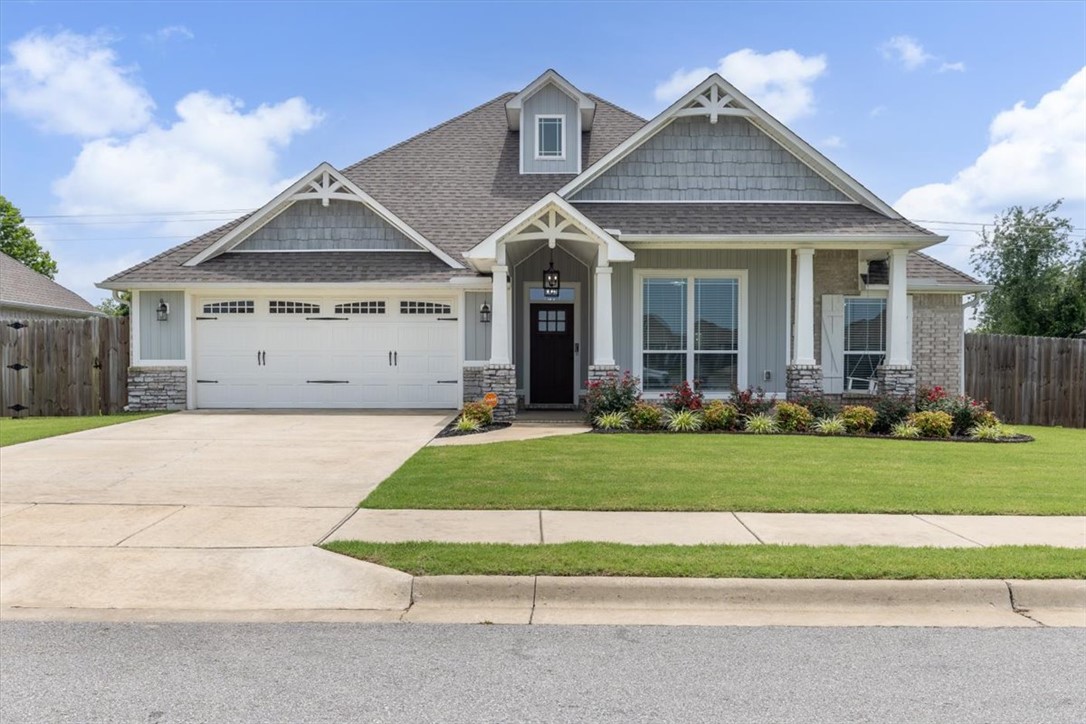 Like new & close to it all, this charming home is only 11 miles from the spectacular new Walmart Home Office Campus and is in a much-desired growing community. The welcoming front porch of your 4-bedroom home is complete with an inviting hanging woodswing in this craftsman style stunner. Don't miss the wood beam, the woodwork for your entertainment center & fireplace, and the beautiful framework around your massive, oversized windows. Your deluxe kitchen has granite countertops, gorgeous gas range, built in oven & microwave, BOSCH dishwasher, & your refrigerator stays! Your split floor plan has your 3 bonus bedrooms & full bath on one side, & your primary suite & laundry room on the other (where your washer and dryer also stay!). Your primary ensuite has luxury finishes, making it your perfect escape at the end of the day. Also, peak the workbench in your spacious garage. Your neighborhood perks include a dog park, playground, pickleball-basketball-volleyball courts, soccer field, NWA MTN bike trail access & more!