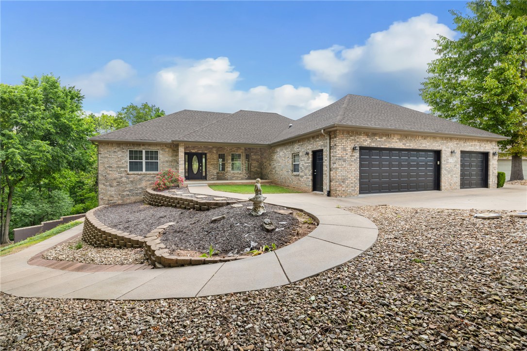 Stunning lake-living lifestyle retreat situated on nearly a half acre park-like lot.  This home has been refreshed with new carpet throughout and all exterior doors have been newly painted.  Located on a quiet cut-de-sac with easy access to Lake Lock Lomond, you are steps away from a public boat launch, world-class hiking and biking trails.  The open floor plan is bathed in natural light, featuring a sunroom with large windows that capture year-round partial lake views.  The main level offers a split bedroom layout, while the finished walk-out basement presents and incredible opportunity for an AirBnB or mother-in-law suite, complete with a full second kitchen and a private entrance which is only accessible from outside the home.  Outdoor living is a dream here, with 4 spacious decks, a gas fire pit, over-sized 3 car garage, a 245 sq ft heated and cooled and massive unfinished storage space.  From the modern interior updates to the incredible income potential, this home offers the best of Bella Vista living.