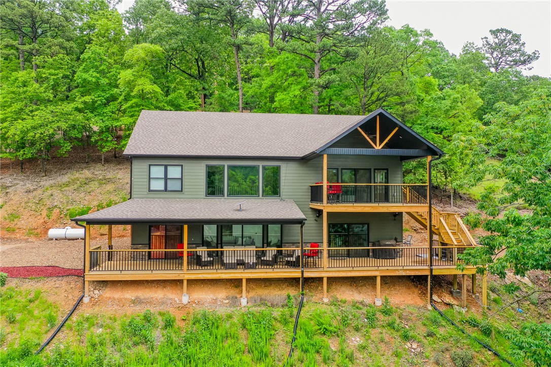 Stunning furnished lakefront retreat on Beaver Lake's Clearpoint Cove w/ STR potential! Expansive windows and soaring ceilings flood the home with natural light and frame breathtaking water views. Whether you're in the kitchen, living room, game room, or out on the deck, the lake is always the star of the show. Thoughtful design w/ 3 bedrooms (2 ensuites), a bunk room, & 3.5 baths. Features include: quartzite countertops, a gas range, & double ovens, 2 decks, game room, hot tub, fire pit, & a co-owned dock complete with a swim deck for easy lake access. Gentle walk to the shoreline makes enjoying the water effortless. Bordering Hobbs State Park, this property offers not just a home, but an outdoor experience with hiking and nature at your doorstep. Whether you're looking for a full-time residence, weekend escape, or investment opportunity, this lakefront haven delivers. Schedule a showing today!