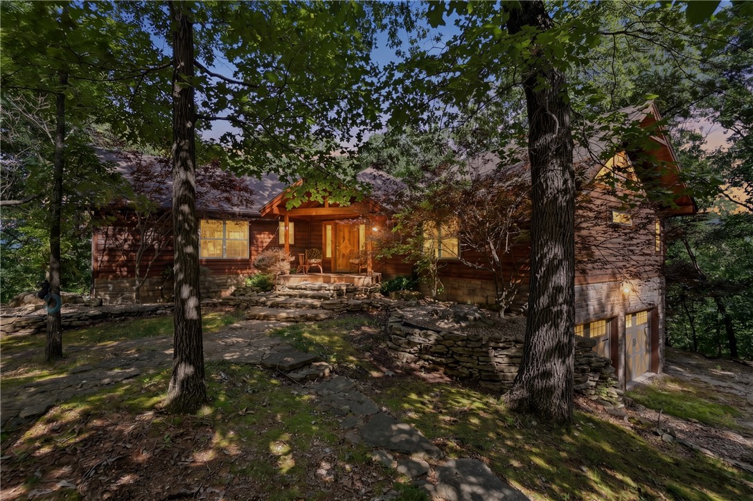 Lake Area Privacy on 39.40 wooded acres.   Ridgetop Custom Built Home with private Circular Drive and 30x40 Metal insulated building, equipped with RV hookup.   Two car garage on lower level with easy access.  This home is like no other.  Custom made decorative doors throughout, high wood ceilings, open floorplan, wood burning Fireplace, Granite breakfast bar, gourmet kitchen, wood floors, walls and ceiling, steel beam behind wood beams.  2  Primary bedrooms with private baths w jacuzzis on Main level and nice walk in shower. One has a sleeping loft (which their grandkids love.)  Third guest room and bath on lower level off hallway of spacious Family Room with Gas Fireplace.  Great outdoor living spaces complete with a grill kitchen.  Lower level has estate style high black metal fencing to prevent the deer from eating all the decorative plants.  Dual Propane Central Heat/Electric Air  systems and two Hot water tanks, one on each floor. Property has 2 miles of ATV trails to Corp Marker. Boat slips are 9/10 m drive