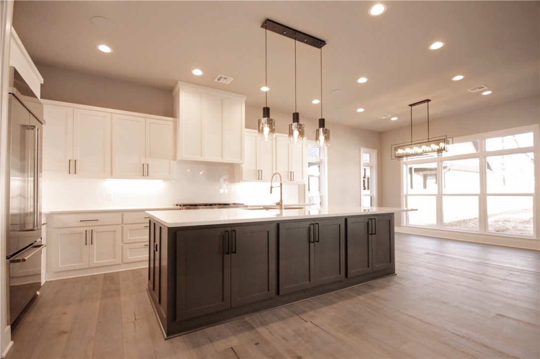 Modern Downtown Bentonville masterpiece w/ open floor plan,3 car garage & upgrades.Awesome location in the heart of the fast growing Downtown Bentonville!Enjoy being seconds from all the fun & excitement Bentonville has to offer.Close to Walmart Home office.The square, shops, schools, & restaurants are all in your backyard!Enjoy the ultimate living room w/ linear gas fireplace, tons of natural light & exposed custom wood beams. Kitchen features large island, quartz counters, double oven, walk in pantry, custom cabinets, 6 burner w/ griddle gas cooktop, oversized refrigerator, & matching KichtenAid appliances!Wetbar area w/ sink, microwave & beverage fridge servicing the living room & outdoor area.4th secondary bedroom on main level or study.Luxurious master bedroom w/ spa like master bathroom.Soaking tub, double sinks & walk-in tile shower w/ rain head!Massive master closet with access to the utility room.Upstairs has two large bedrooms & bonus room with wetbar!Large covered patio w/ fireplace & built in grill.
