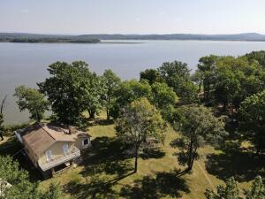 Riverfront living you have been searching for is finally here. Enjoy a quiet secluded lifestyle on 2.52 acres with large trees all around. Overlooking the Arkansas River, this home offers multiple decks and a screened in porch for your enjoyment. Inside features a cabin lake house style with a  floor to ceiling rock fireplace in the living area for a cozy ambiance. Off the living room is the formal dining and kitchen area both overlooking the water. The kitchen features an eat in bar style seating area with a large space for entertaining. Upstairs features a second living room, guest bedroom, and large master bedroom suite with views overlooking the lake and a private deck. All of this complete with a 50x24 shop building, concrete floors, electric, spray foam insulation, & 3 roll up doors.