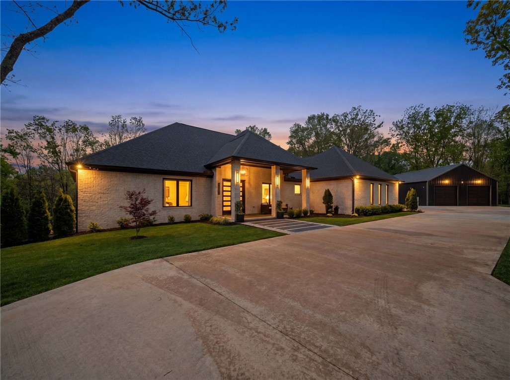 Custom-built in 2024, this luxurious home brings refined design and an unbeatable location. Walls of windows flood every room with natural light, creating an airy, open feel throughout. The kitchen centers around a generous island with stone countertops, shaker cabinets, a bold backsplash, and a ZLine range beneath a custom hood, all anchored by a wood-accented tray ceiling over the custom built-in dining table. The living room offers a fireplace and its own tray ceiling for tranquil evenings in. The outdoor living space is seamless and designed for entertainment. Spa-inspired bathrooms feature tiled walk-in showers and a soaking tub. Direct trail access connects you to the Mighty Pine MTB trail, linking riders to all of Bella Vista, Bentonville, and the Razorback Greenway with a 20-30 min bike ride to DT B'ville. The internal safe room offers comfortable and convenient safety right inside, and the 1200 ft. shop has everything you'd expect with security that matches the safe room (same door!) Whole house generator!