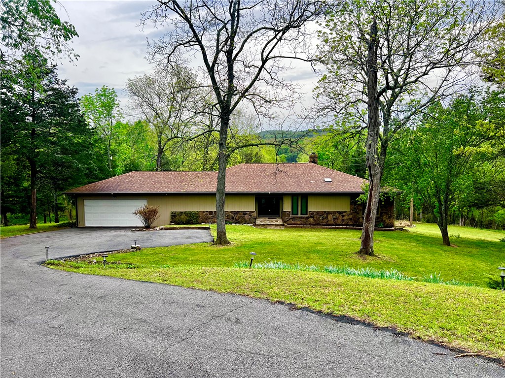 Sprawling lakefront retreat with easy walking access to the waters edge. This large home has lots of interior and exterior entertaining spaces. There is even a swanky wet bar built in for ease of serving guests. The sunken living room is open and inviting with a large stone wall fireplace surround and an entire wall of windows overlooking the totally amazing sunroom and showcasing the landscaped back yard with a lovely year round view of Table Rock Lake. The well appointed Primary bedroom has a private en suite bathroom and multiple closets with additional storage to keep things tidy. There are two nice sized extra bedrooms and even a private office located just off the living room. The kitchen was recently remodeled and updated with new countertops and stainless appliances. Enjoy easy access to the grill in the sunroom with a private staircase from the kitchen. The garage will leave you speechless, plenty of room to park your truck, boat and the golf cart! Island Marina, Pool, Playground & Golf all within 1 mile.