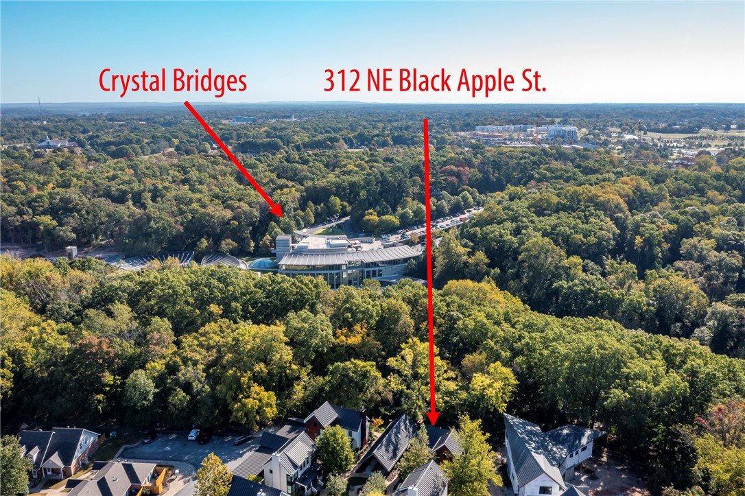 The "Trail House."  ONE-OF-A-KIND and rare opportunity to live overlooking Crystal Bridges Museum of American Art!  Premiere address in the heart of Downtown Bentonville, located in the Black Apple pocket community.  This professionally designed thoughtful community connects you directly to the Crystal Bridges walking/bike trail right out your back gate.   Modern and Sleek and Upgrades throughout, this is the perfect home or weekend getaway.  Covered back and front porches to enjoy, interior upgrades throughout, casual yet sophisticated floorplan featuring 3BRs/2.5BA.   Community features common green space with fire pit and clubhouse for casual gatherings.  Only few can wake up every morning to views of Crystal Bridges Museum and walk out their back gate to be there!   Hurry to make this special home yours!