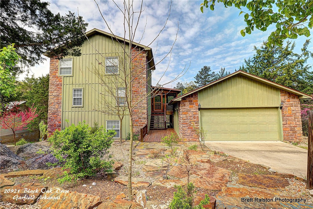 Come home to this lakefront cabin with boat slip! Open floor plan with large kitchen, floor to ceiling stone fireplace, vaulted wood ceilings and spectacular wall of windows with Low-E glass. The outdoor space includes 2 levels of decks, upgraded landscaping in the front and back of home, screened in porch that makes it a perfect place to entertain family & guests! One bedroom and bath per level for added privacy. And,plenty of storage in the oversized 2 car garage to store all your lake toys & equipment.