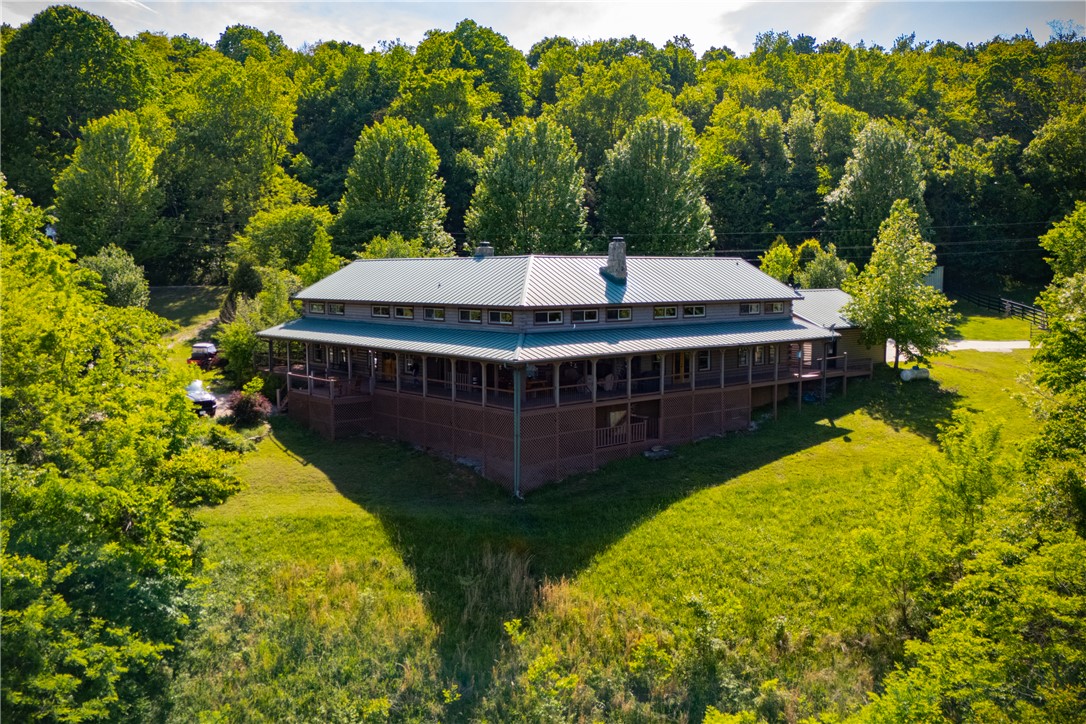 A truly one-of-a-kind legacy estate spanning nearly 100 acres of Ozark landscape, offering breathtaking panoramic views, abundant wildlife, and unmatched privacy. Named the "Black Bear Lodge", this property has endless possibilities such as a family compound, retreat, or hunting lodge. The estate includes separate residences- a custom-built main home, cottage house, and bunk house. The main home is thoughtfully designed to capture the surrounding views, with scenic vistas from the kitchen, a floor-to-ceiling native rock fireplace in the living area, formal dining room, and an upstairs loft game room. With 5 bedrooms and 4.5 bathrooms, the home offers ample space. The land itself features two pastures, a pond, a creek, and trails through the property. A barn with covered space provides additional storage and a place to enjoy the outdoors year-round. Known for its diverse wildlife, this sportsman’s dream presents a rare opportunity to own a private retreat where the beauty of the Ozarks and adventure come together.