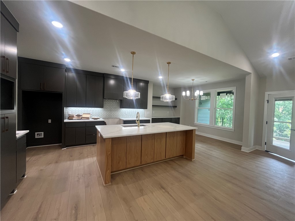 Luxury modern single-level living just steps from Flo Ride Bike Trail & less than a mile from Lake Ann! Thoughtfully designed for the ultimate Bella Vista lifestyle, this home blends elegance, comfort, & functionality with peaceful Ozark views. The light-filled great room showcases soaring cathedral ceilings, oversized windows, a stunning honed limestone fireplace, custom built-ins, & luxury vinyl plank flooring throughout. The chef's kitchen features a massive quartz island, custom cabinetry, & walk-in pantry. Flexible floor plan offers a 3rd sleeping area/bonus room, 2 additional bedrooms, dedicated office, & 2.5 baths. The private primary suite includes a spa-inspired bath with a soaking tub, custom tiled shower, & spacious walk-in closet. Relax on the large covered deck overlooking the wooded setting. Oversized 2-car garage. A rare opportunity to enjoy luxury living in one of Bella Vista's premier recreational areas with exceptional privacy & an unbeatable location.