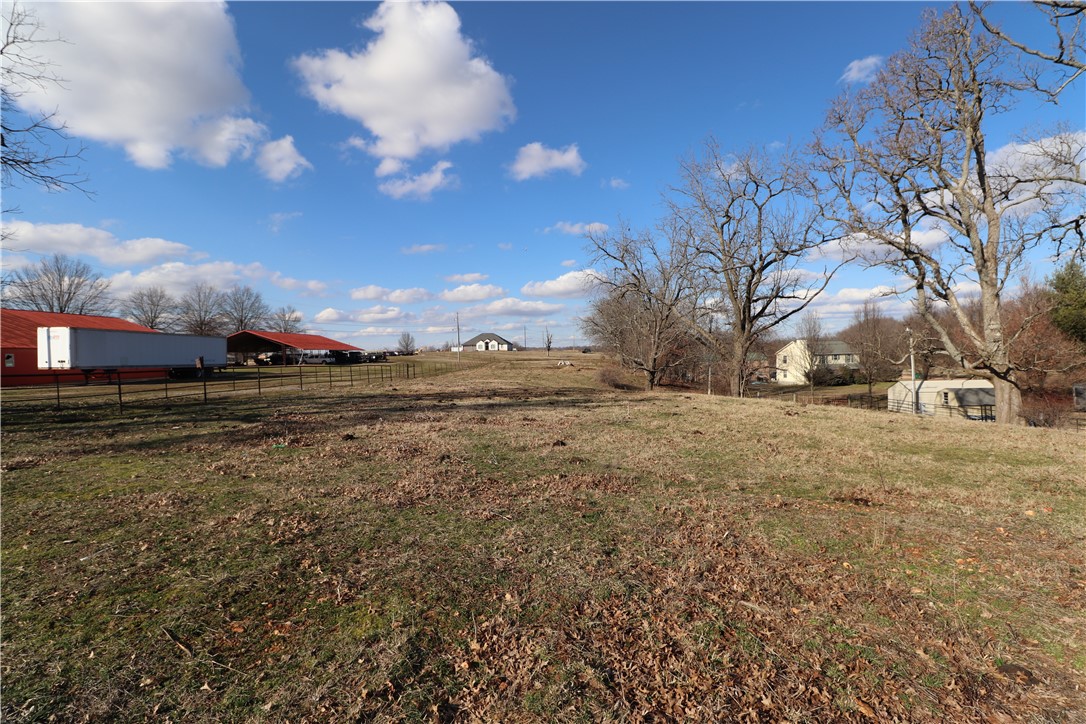 2.16 +/- level acres with paved road frontage, Tontitown water, natural gas, ozark go, sewer line easement, and a pond