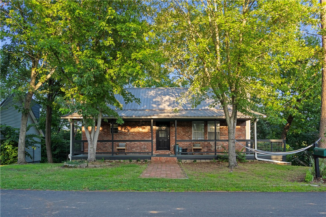 Rare fully-furnished retreat offering one home with three distinct living areas, each with private entrance. Set on three wooded lots totaling .64 acres, this property delivers privacy, forest views, and turnkey income potential. Located near the Hwy 12 boat launch, Prairie Creek Marina, downtown Rogers, and Bentonville, this home combines easy lake living and everyday convenience. The flexible layout supports lake getaways, multigenerational living, guest hosting, or STR use. Giant two-level deck provides space for guests, activities or solitude. The 2023-built 576 sq ft studio above the detached garage includes a kitchenette, full bath, sleeping loft, and private laundry. Tastefully decorated and furnished with 2.5 years of rental history. An additional vacant lot adds future options, while the wooded setting provides the quiet backdrop you crave. A turnkey property with exceptional versatility and income potential. Not just a lake house - it's an opportunity (one that won't last). Schedule a showing now!