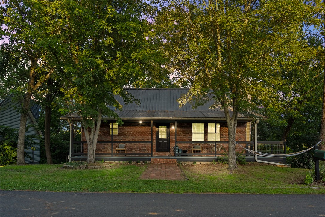 Rare fully-furnished retreat offering one home with three distinct living areas, each with private entrance. Set on three wooded lots totaling .64 acres, this property delivers privacy, forest views, and turnkey income potential. Located near the Hwy 12 boat launch, Prairie Creek Marina, downtown Rogers, and Bentonville, this home combines easy lake living and everyday convenience. The flexible layout supports lake getaways, multigenerational living, guest hosting, or STR use. Giant two-level deck provides space for guests, activities or solitude. The 2023-built 576 sq ft studio above the detached garage includes a kitchenette, full bath, sleeping loft, and private laundry. Tastefully decorated and furnished with 2.5 years of rental history. An additional vacant lot adds future options, while the wooded setting provides the quiet backdrop you crave. A turnkey property with exceptional versatility and income potential. Not just a lake house - it's an opportunity (one that won't last). Schedule a showing now!