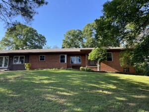Spacious 2863 square foot home full of character and functionality with room to grow. Centrally located on large lot close to downtown Russellville, Dardanelle, and multiple schools. Interior features 5 bedrooms 3 full bathrooms, 2 living areas, and formal dining room. Perfect for large families or students. Paved circle drive with easy entrance into the large 2 car attached garage. Exterior features a fully fenced backyard, flagstone patio, small outbuilding, and walk in crawlspace. Stunning well established trees for added shade and privacy. Roof and new windows installed 2013. Two HVAC systems, two hot water heaters, and bonus fireplace included.